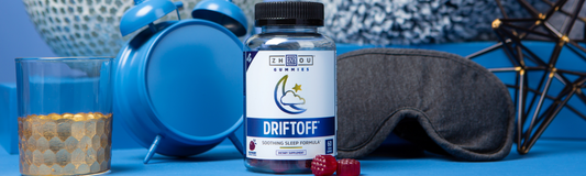 Bottle of Driftoff next to blue alarm clock, glass, eyemask and dice