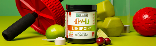 Lyte Up pre-workout powder next to ab-roller, bottle, strawberry and lemon